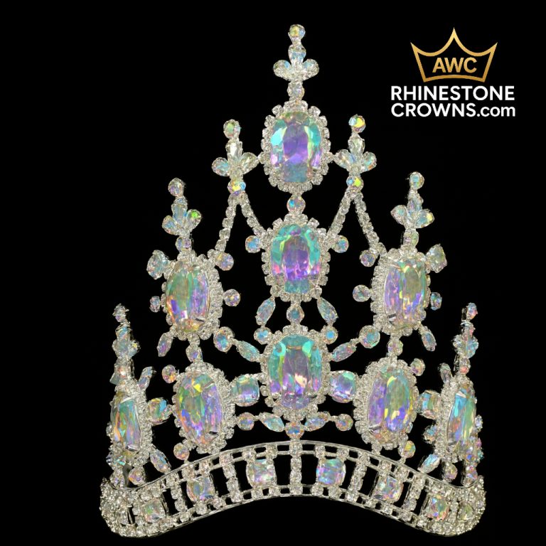 The Kimmy Series - 6" Crown is a sparkling iridescent rhinestone quince crown with large oval gems and intricate detailing, shown on a black background. The AWC RHINESTONECROWNS.com logo is in the top right corner.