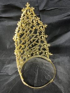 The Jingle All The Way Series-12" Crown: a gold, intricately designed bridal crown featuring arched filigree with floral and circular patterns, showcased against black fabric.