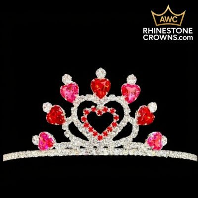 The Sweet Sparkle Series 8" Crown, featuring red and pink heart-shaped rhinestones in a central heart design, is displayed on a black background. Ready to ship now with more stock arriving late December from AWC Rhinestone Crowns.